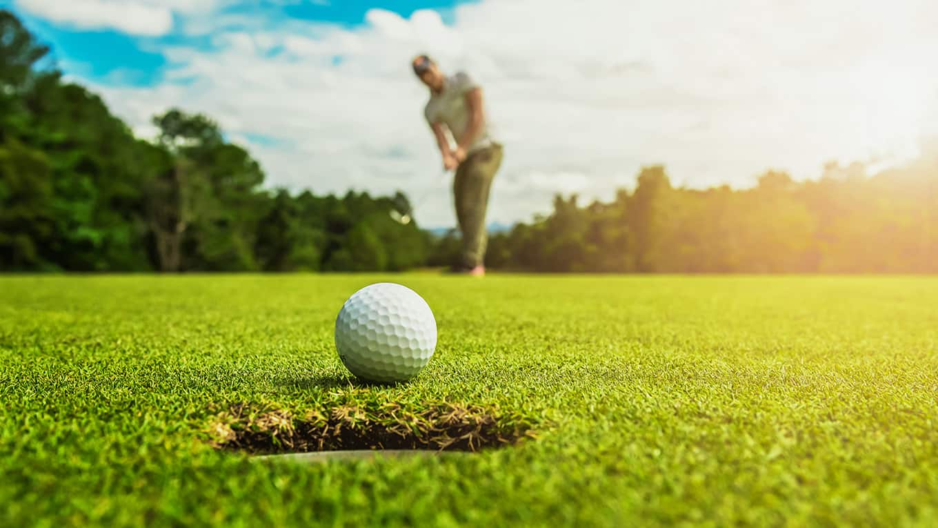 Golfer beim einlochen.