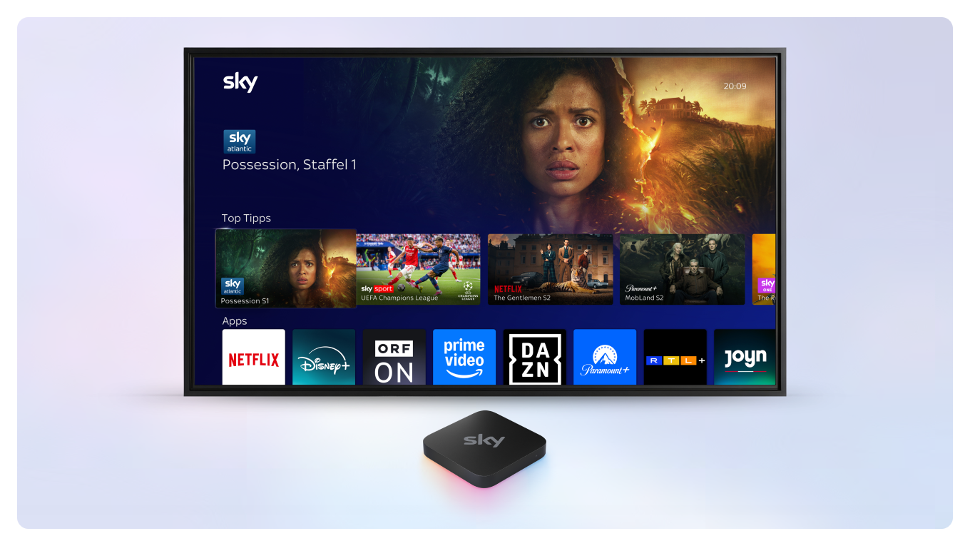 Sky Stream Box vor einem Fernseher, auf dem das Sky Stream UI zu sehen ist.