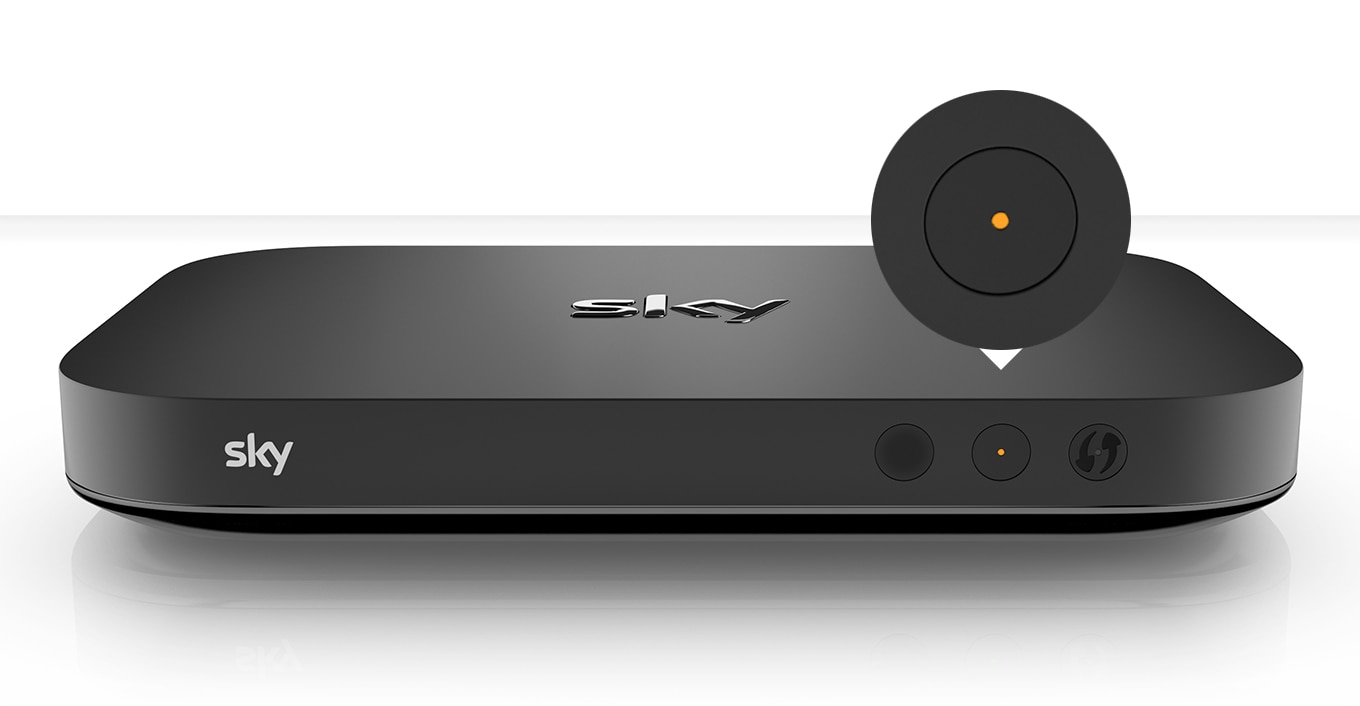 Schwarze Sky-TV-Box mit Sky-Logo, zwei Tasten mit orangem Licht im aktiven Standby-Modus