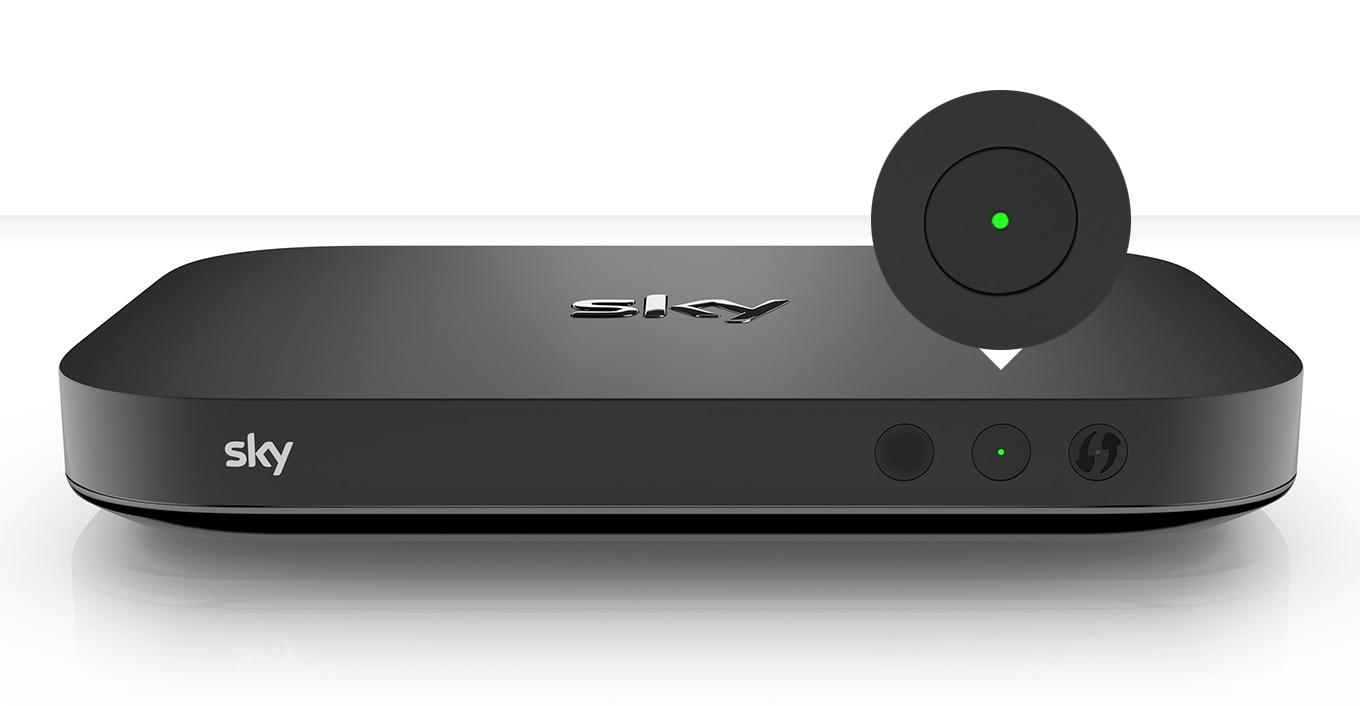 Schwarze Sky-TV-Box mit Sky-Logo, zwei Tasten mit grünem Licht im Einschaltmodus